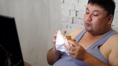 Fat man eating a Burger with fries