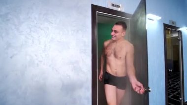 İki adam ve bir kız saunadan çıkar ve gülümserler.