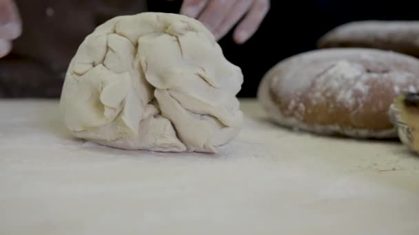 Der Bäcker knetet Teig auf hölzerner Oberfläche — Stockvideo