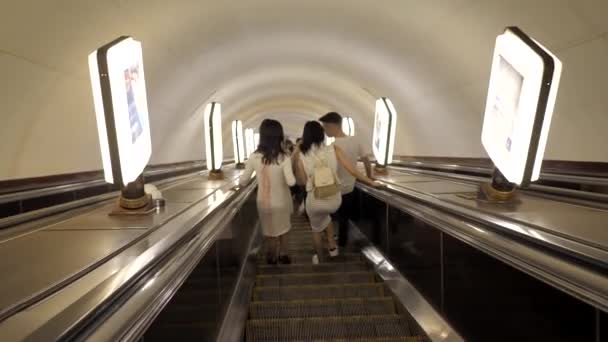 Barátok beszélgetnek és sétálnak lefelé a mozgólépcsőn a metróban.. — Stock videók