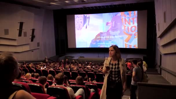 En el cine, la gente se sienta y espera el comienzo de la sesión . — Vídeo de stock