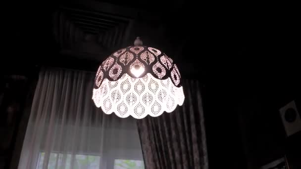 Dobrý večer. V místnosti osvětlené jediným starožitným krajkovým stínítkem lampy — Stock video