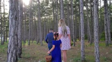 Oğlu ve kızı olan genç bir anne çam ormanında yürüyor.