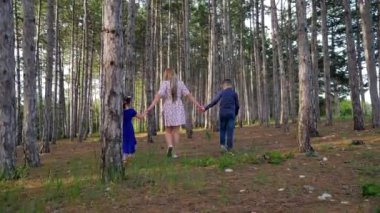 Oğlu ve kızı olan genç bir anne ormanda yürüyor.