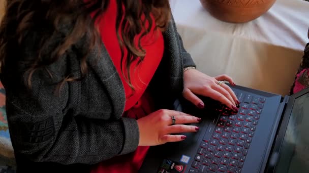 Ein junges Mädchen arbeitet in einem orientalischen Raum an einem Laptop — Stockvideo