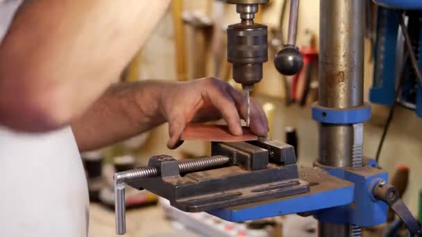 El maestro usando una fresadora hace un agujero en un pedazo de cobre — Vídeos de Stock