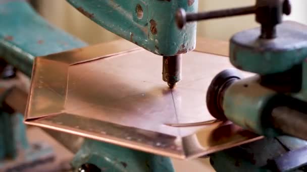 The master, using a copper sheet cutting machine, cuts a circle into the product — 비디오