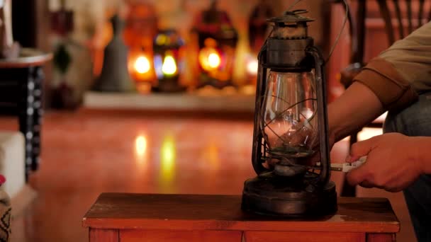 Muž středního věku rozsvítí starou petrolejovou lampu v útulném pokoji — Stock video