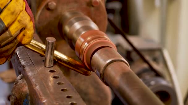 The master grinds a part of a copper product using a lathe — Stock Video