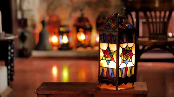 A man removes the tiffany lamp from the shelf in a cozy room in the Eastern style — 비디오