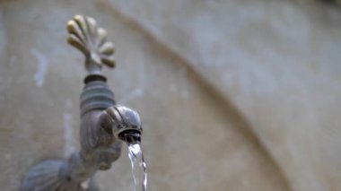 Doğu tarzında eski bir taş vinçten su akar. yakın plan