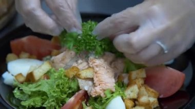 The chef prepares salads. Decorate the salad with herbs