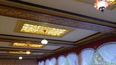 Graceful ceiling in the room in Oriental style. Lanterns with colored glass
