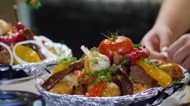 Şef maydanoz ve soğanla süslüyor. Kazanda pişirilmiş.. 