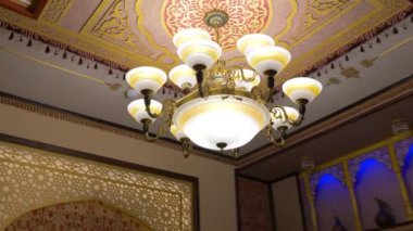 Graceful ceiling in the room in Oriental style. Chandelier in Oriental style