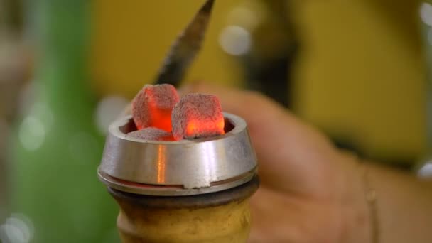 The young man is preparing a hookah. puts the bowl with coals. — Stok video