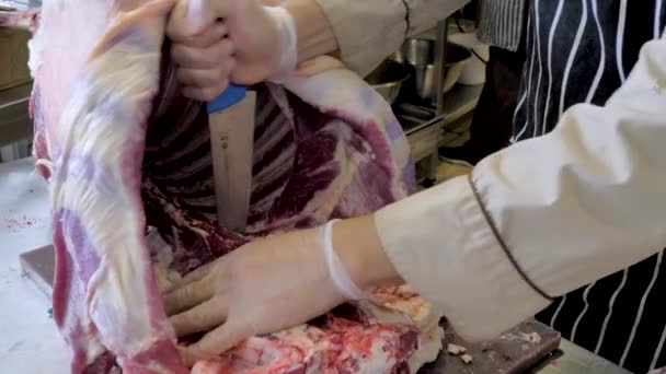 Corte de carne de carneiro. Faça um sacrifício de uma ovelha em Kurban Bayram. Açougueiro carne cortada — Vídeo de Stock