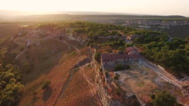 Tepe tepe ve orman manzaralı bir vadi. Ortaçağ evleri. gün batımı