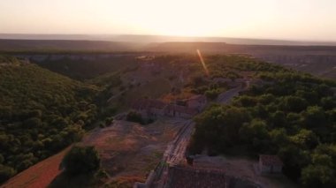 Tepe tepe ve orman manzaralı bir vadi. Ortaçağ evleri. gün batımı