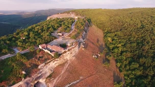 Blick von oben auf das Tal mit Felsen und Wald. die mittelalterlichen Häuser. Sonnenuntergang — Stockvideo