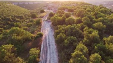 Tepe tepe ve orman manzaralı bir vadi. Ortaçağ evleri. gün batımı