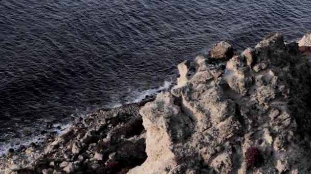 Крутий спуск зі скелі. Море спокійне і темне — стокове відео
