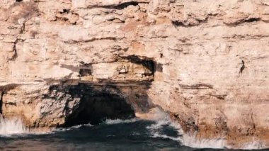 Dalgalar kayayı dövüyor. Mavi su. Güneşli yaz günü