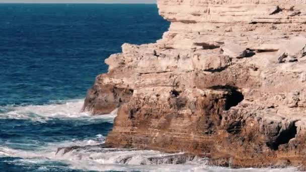 The waves beat on the rock. Blue water. Sunny summer day — Stock Video