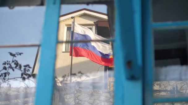 De weerspiegeling in het raam, de vlag van Rusland wapperde in de wind. — Stockvideo