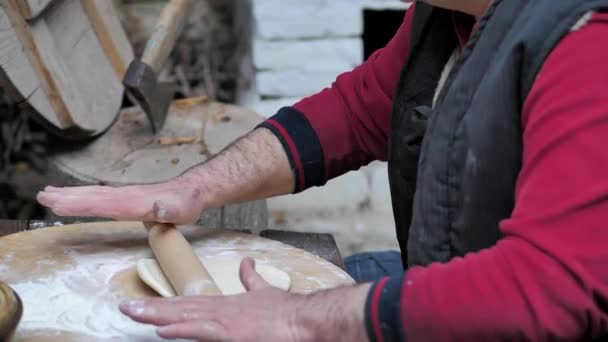 Ο άνθρωπος τυλίγει ζύμη με πλάστη για ψήσιμο επίπεδου ψωμιού στον μεσαιωνικό φούρνο. — Αρχείο Βίντεο