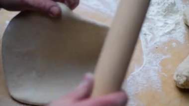 Ortaçağ fırınında ekmek pişirmek için hamuru merdaneyle saran adam.. 