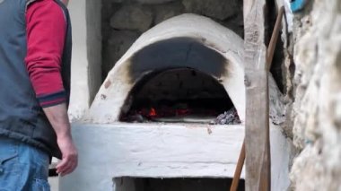 Fırıncı fırının demir kapısını fırında pişirmek ve kapatmak için yassı ekmek koydu.