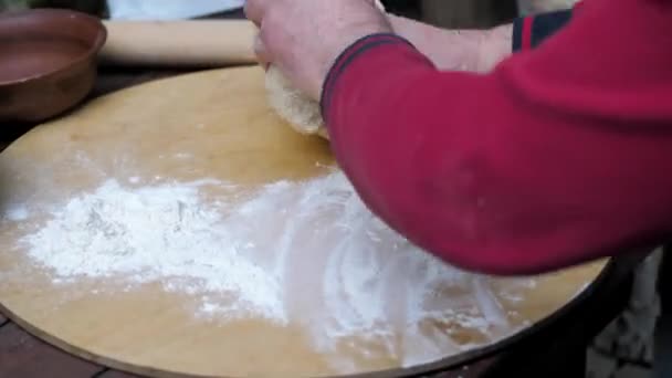 De mens kneedt het deeg, verdeelt het in stukken voor het bakken van plat brood in de oven. — Stockvideo
