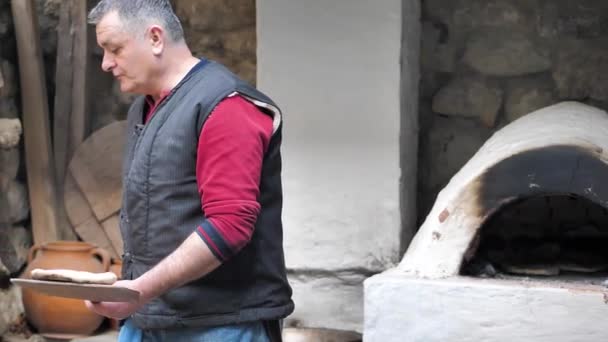 Пекарь достал из духовки лепешки с деревянной лопаткой. — стоковое видео