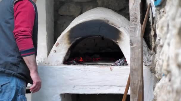 Бейкер поклав підсмажений хліб, щоб випікати і закрити залізні двері плити — стокове відео