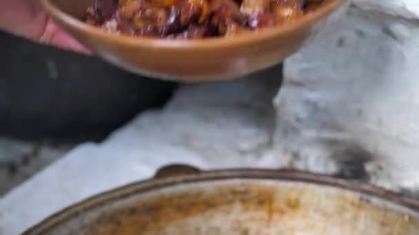 Der Koch legt das fertige Fleisch auf eine Tonschüssel. gebratene Fleischstücke — Stockvideo