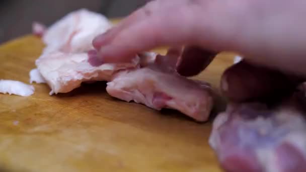 Повар на деревянной доске режет мясо на куски, чтобы поджарить его. макро — стоковое видео