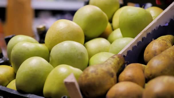 Клиент берет зеленые яблоки в корзину со стойки — стоковое видео