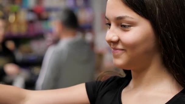 Das junge Mädchen pflückt die Birnen vom Tresen zum Einkaufswagen — Stockvideo