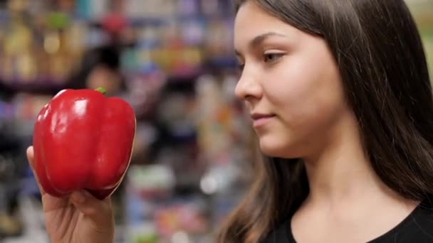 Mladá dívka sbírá červený a žlutý paprika z pultu — Stock video