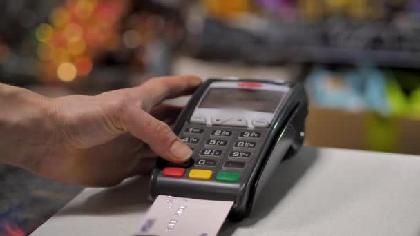Покупатель оплачивает товар через безналичный платежный терминал — стоковое видео