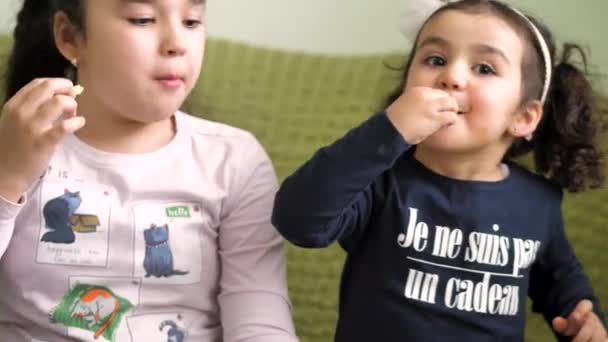 Deux filles frisées aux cheveux bruns mangent des frites, les trempent dans la sauce — Video