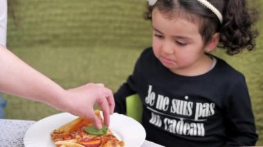 Annem küçük bir kıza bir dilim pizza hazırladı ve yemeye başladı.