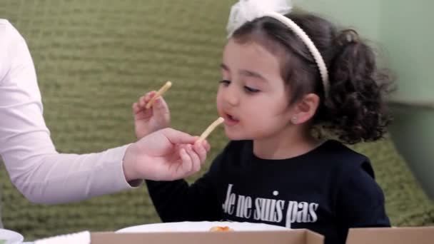 A menina comendo batatas fritas com molho, sorri — Vídeo de Stock