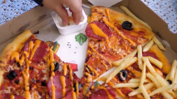 Pizzabezorging. kinderen dompelen de frietjes in witte saus — Stockvideo
