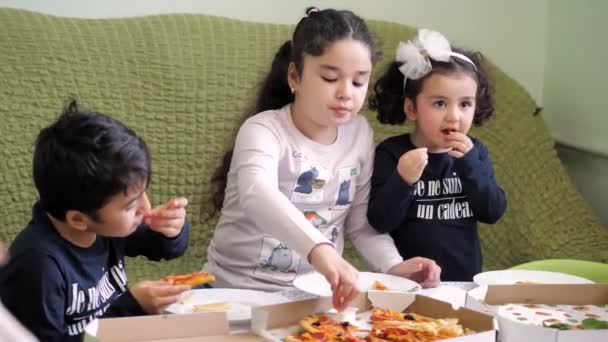 Доставка пиццы. мальчик и две девочки едят пиццу и картошку фри — стоковое видео