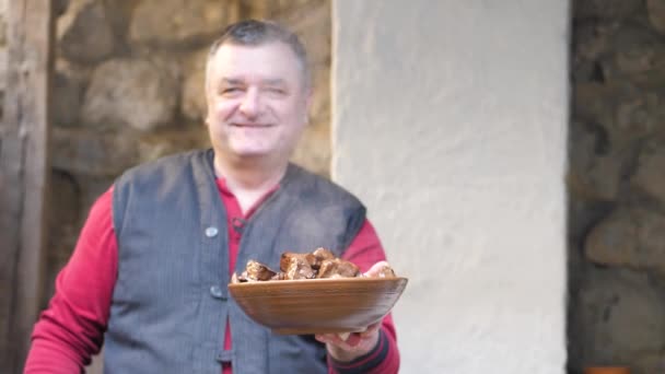 Cook tient dans ses mains un plat de faïence de morceaux de foie de boeuf frit — Video