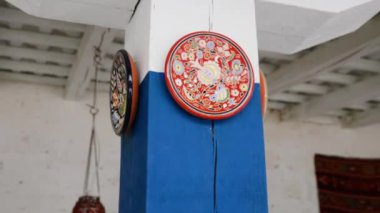 Yazlık terasta. Ahşap sütunlarla süslenmiş kil tabaklar.