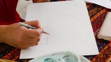 Children learn to draw. girl makes a sketch of the future drawing