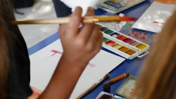 Little girl learns to paint with watercolor paints. Teacher points out mistakes — Stock Video